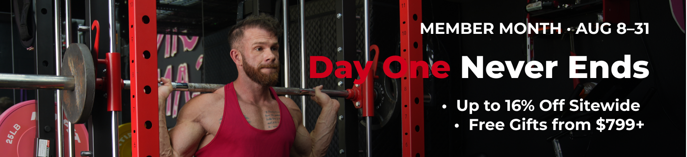 Man in red tank top performing barbell squat inside red power rack