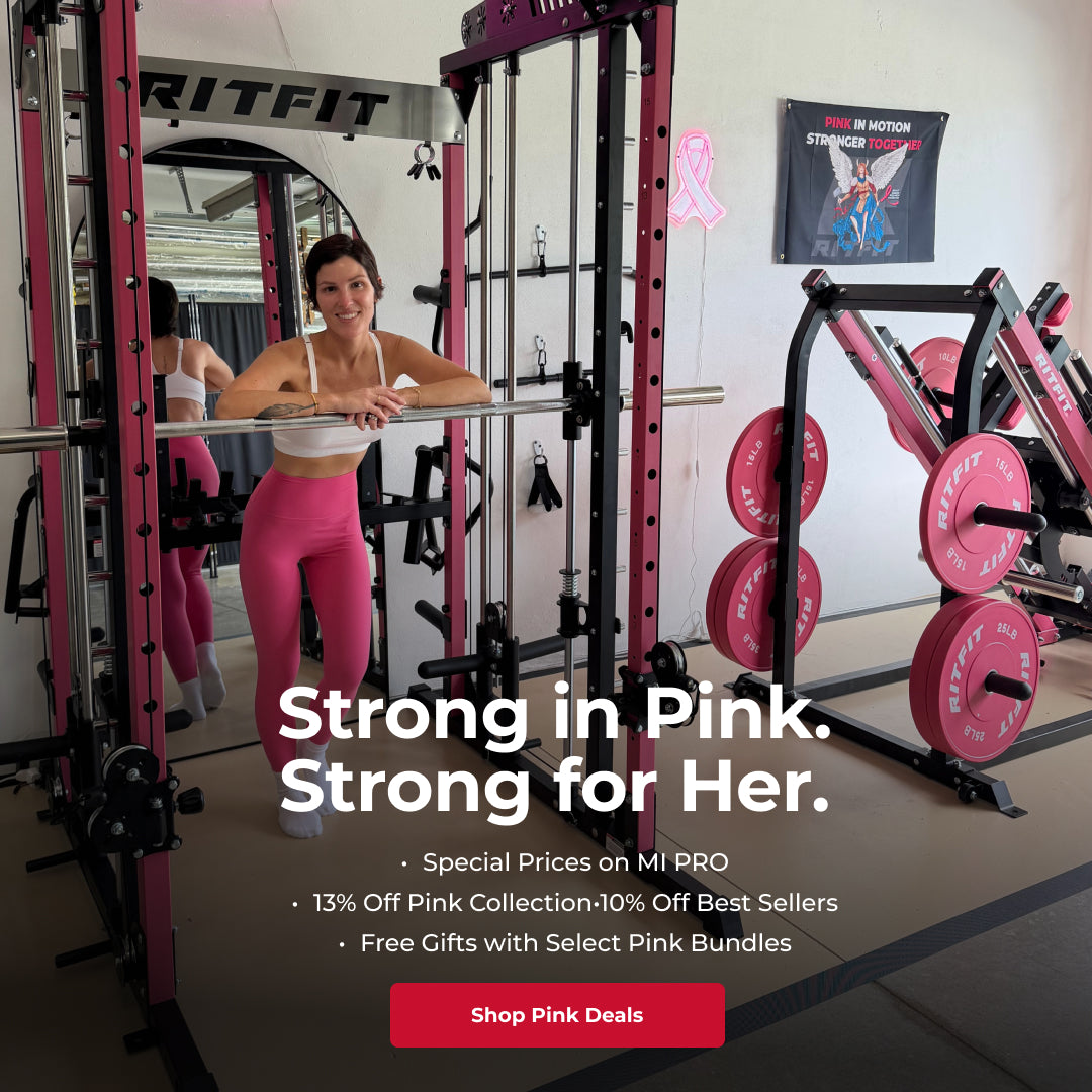 Woman in pink leggings leaning on barbell inside pink RitFit home gym with matching weight plates