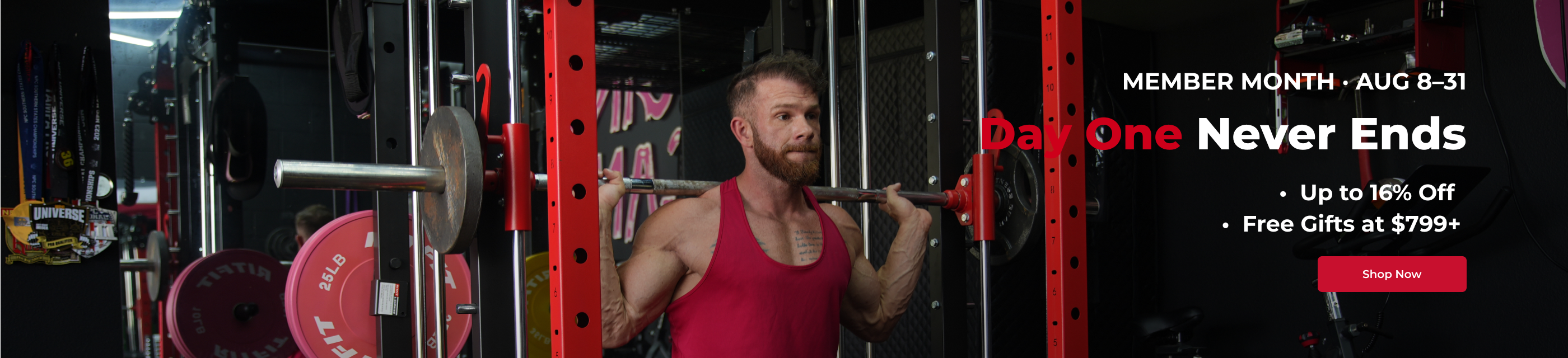 Man in red tank top performing barbell squat inside red power rack