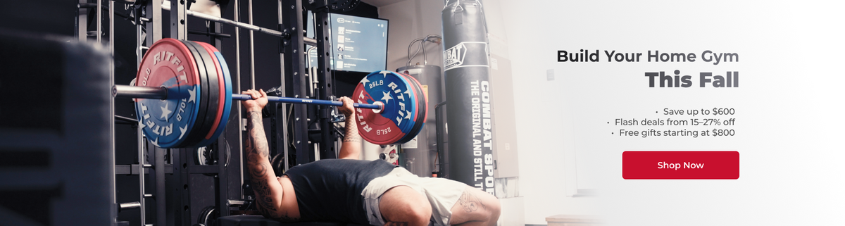 Man bench pressing barbell with red and blue bumper plates in home gym