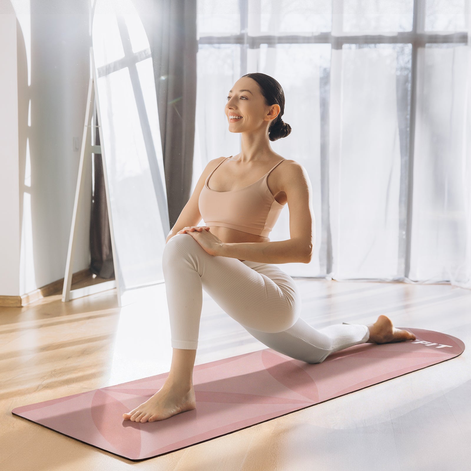 Pink RitFit non-slip yoga mat with textured surface, shown rolled out on a wooden floor for fitness and yoga practice.