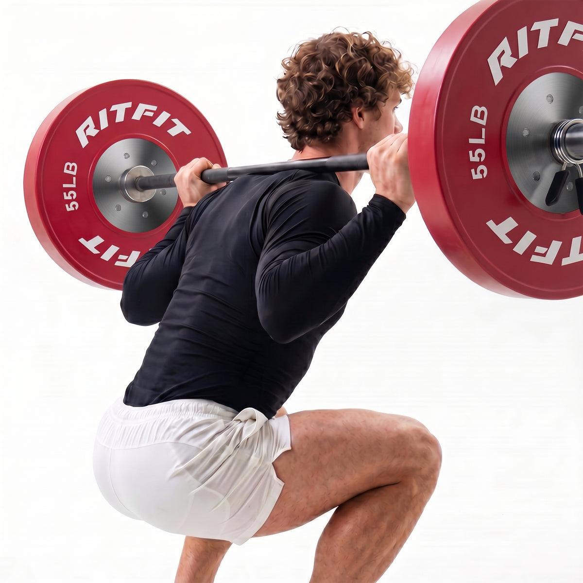Man squatting with red RitFit 55LB bumper plates on barbell
