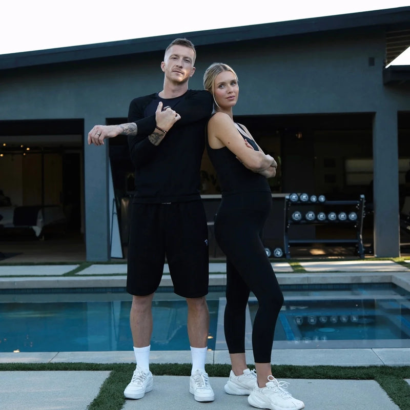 Marco Reus and Scarlett standing in front of their RitFit M3 home gym setup