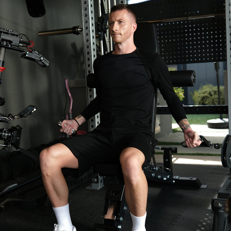 Marco Reus seated on the workout bench of the RitFit M3 home gym